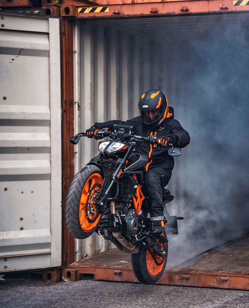 A motorcyclist rides out of a shipping container