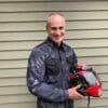 Front view of rider holding a helmet while wearing the REV'IT! overshirt