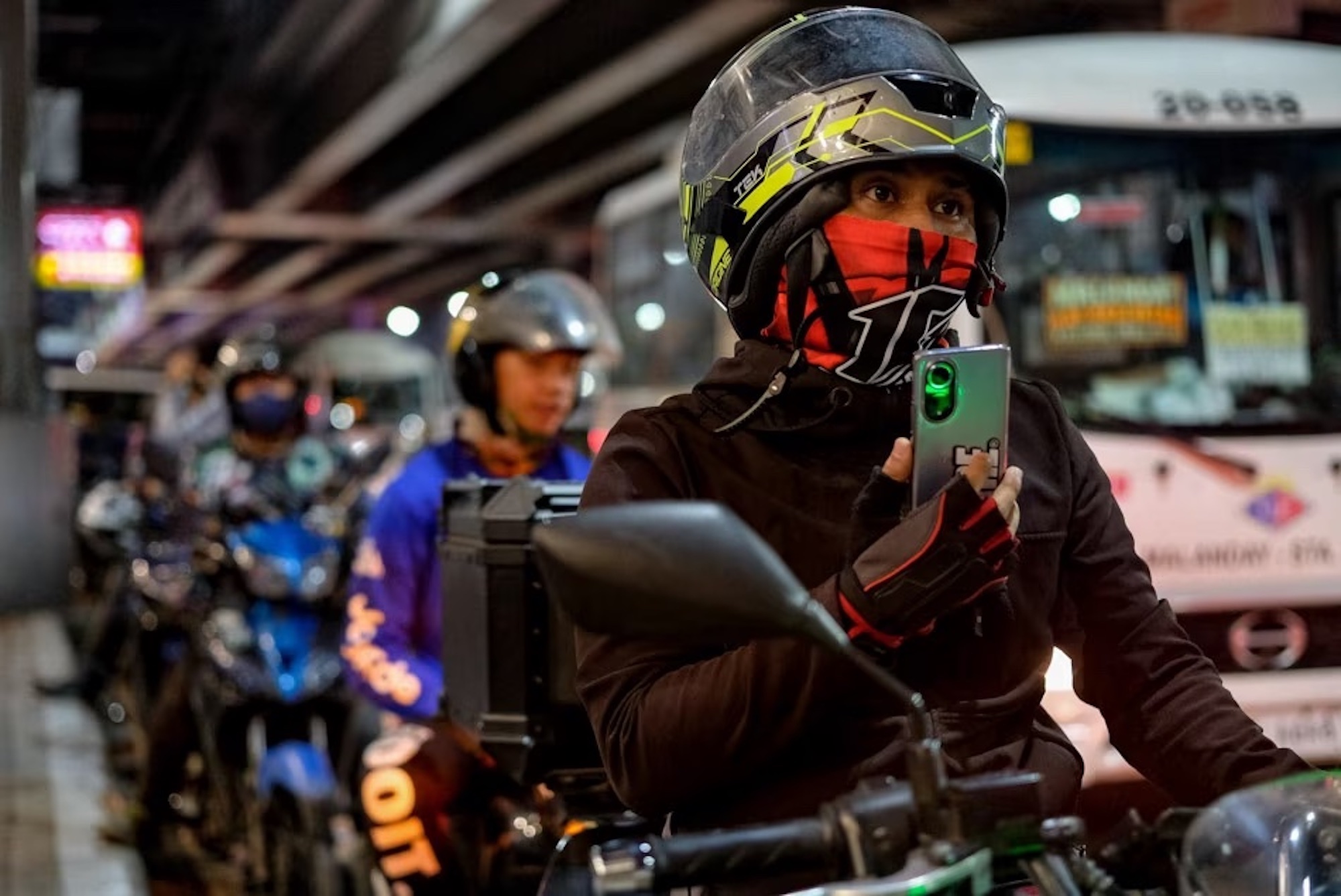 A motorcyclist holding a phone in the Philippines. Media sourced from ABS-CBN News.