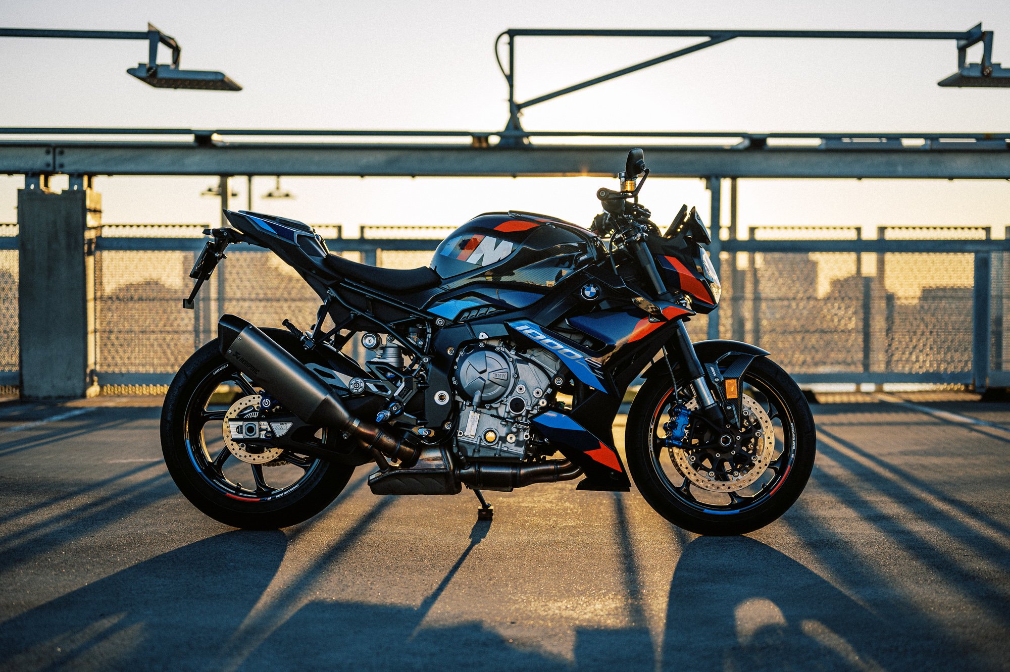 The 2023 BMW M 1000 R motorcycle on a rooftop car park at sunset