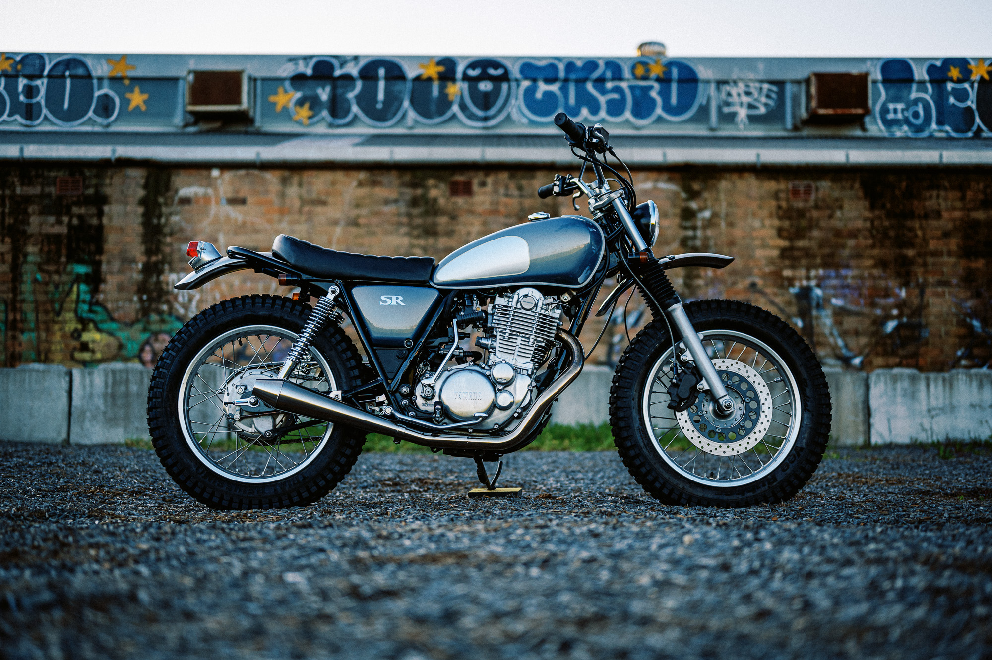 a custom Yamaha SR400 Motorcycle in Sydney at dusk in a vacant lot