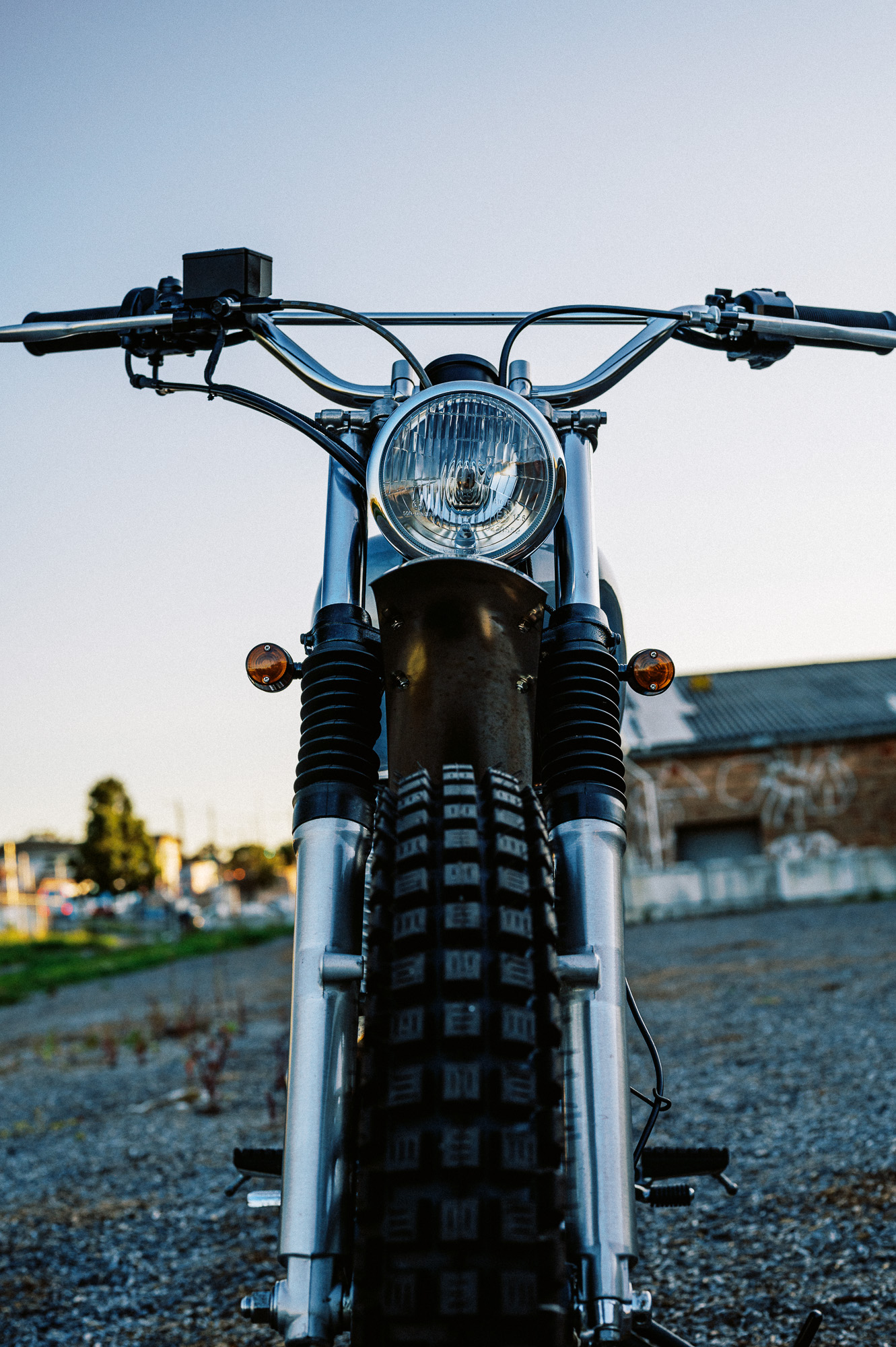 a custom Yamaha SR400 Motorcycle in Sydney at dusk in a vacant lot